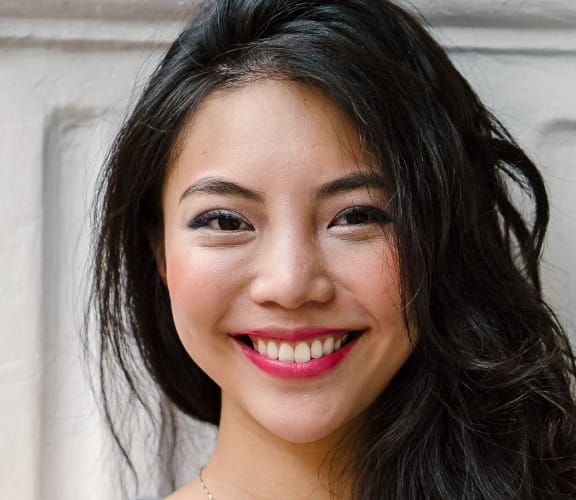 Woman with long dark hair smiling directly at the camera
