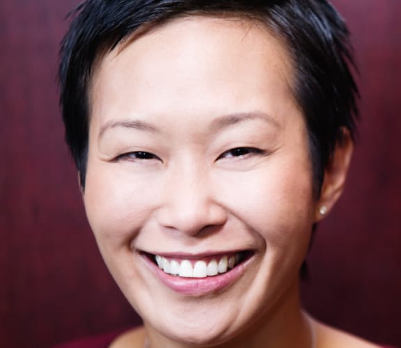 Older woman in front of red wall