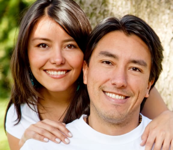 Woman standing behind man and holding his shoulders